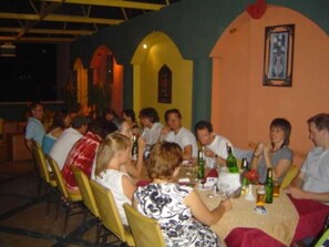 A group of people seated at a table in a restaurant with a simple, functional interior design. - Indiana Hotel Cairo (Giza)