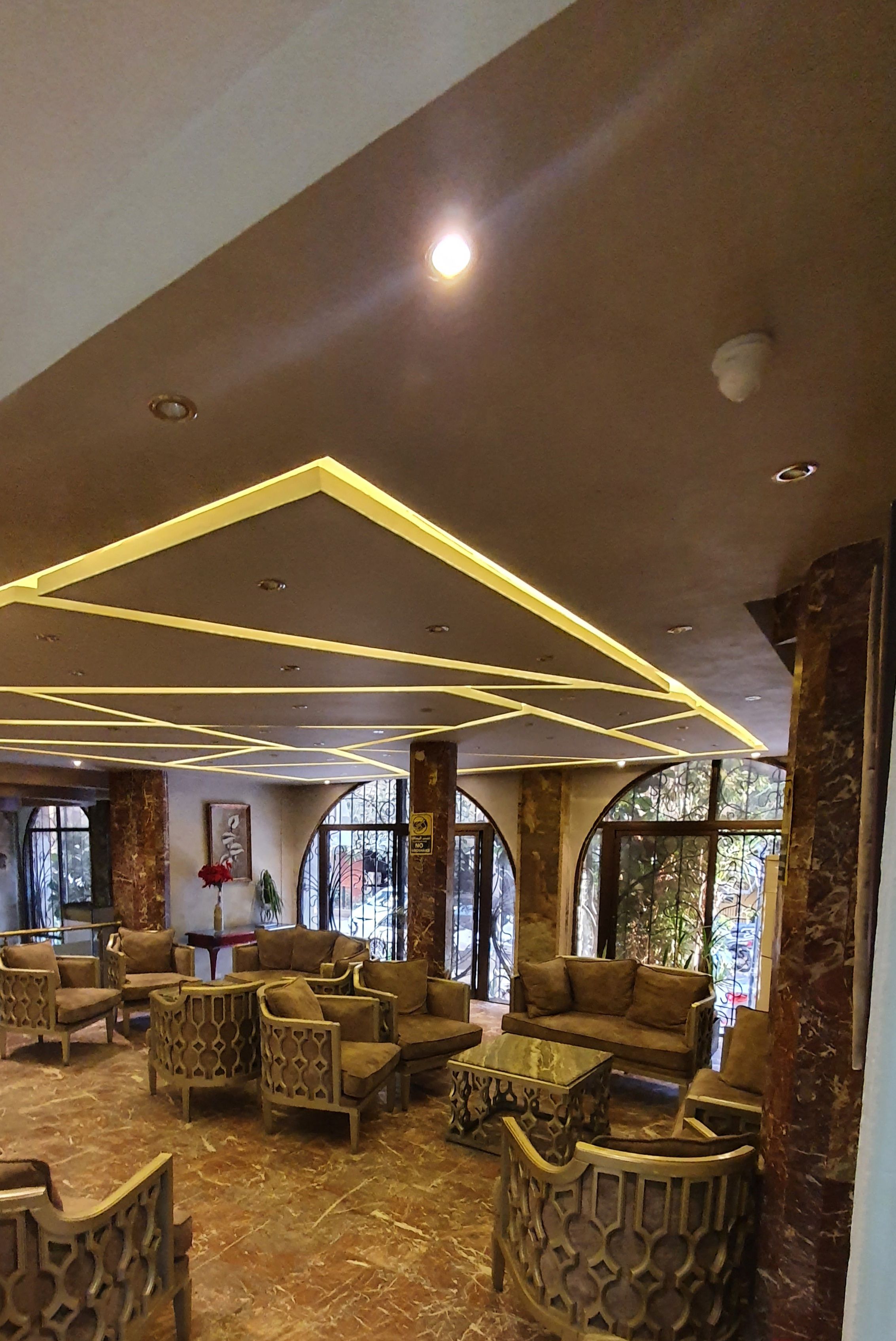 A spacious lobby with a high ceiling, modern lighting, and comfortable seating arrangements.