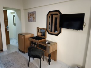 A room with a wooden desk, a chair, a television, and a mirror. - Indiana Hotel Cairo (Giza)