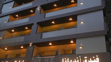 A multi-story hotel with balconies and a sign indicating 'Indiana Hotel' and 'Indiana Hotel' in Arabic.