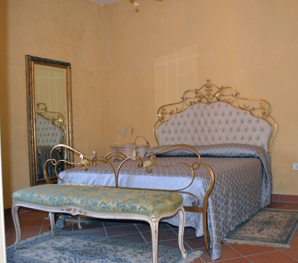 A bedroom with a bed, a bench, a mirror, and a nightstand. - Gallipoli Resort (Gallipoli)