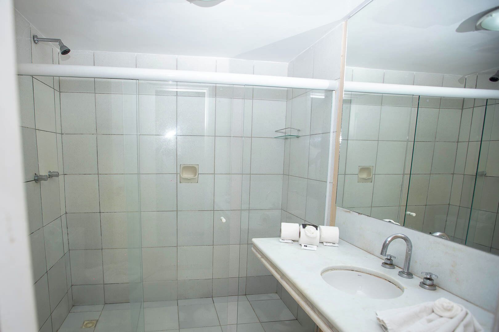 A modern bathroom with a glass shower enclosure, a sink with a mirror, and a toilet.