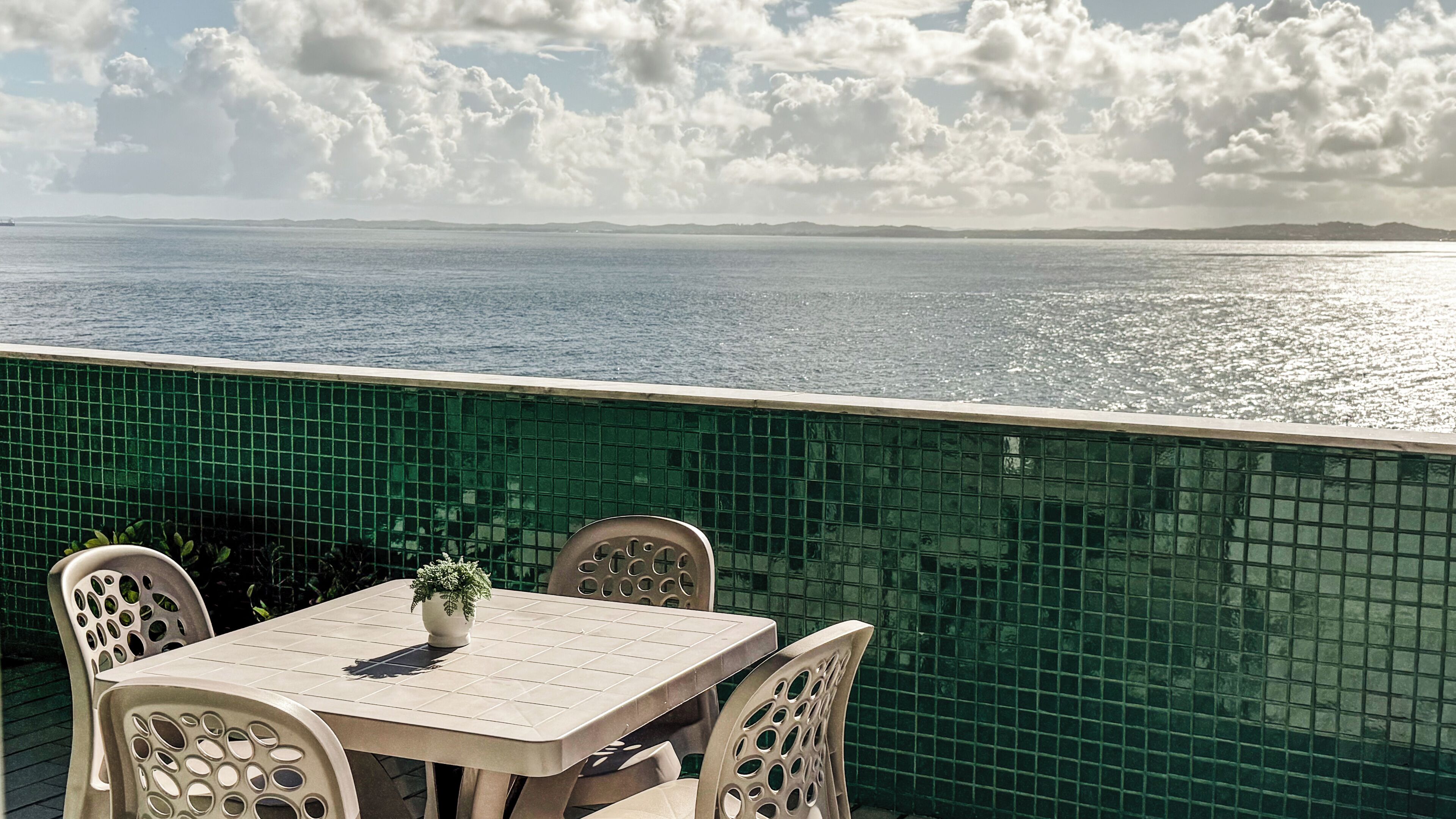 Une terrasse avec une table et des chaises donnant sur un plan d’eau.