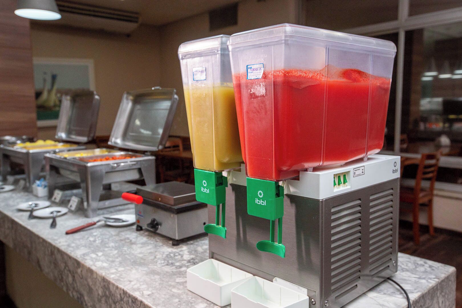 Een buffetgedeelte met verschillende drankdispensers en een ruime keuze aan eten.