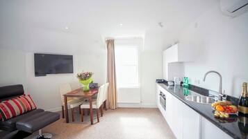 A modern apartment with a living room, dining area, and kitchen.