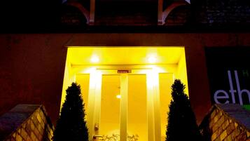 A building with a prominent bay window and a lit entrance.