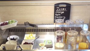A breakfast bar with various fruits, juices, and condiments. - Pastures Hotel (Doncaster)