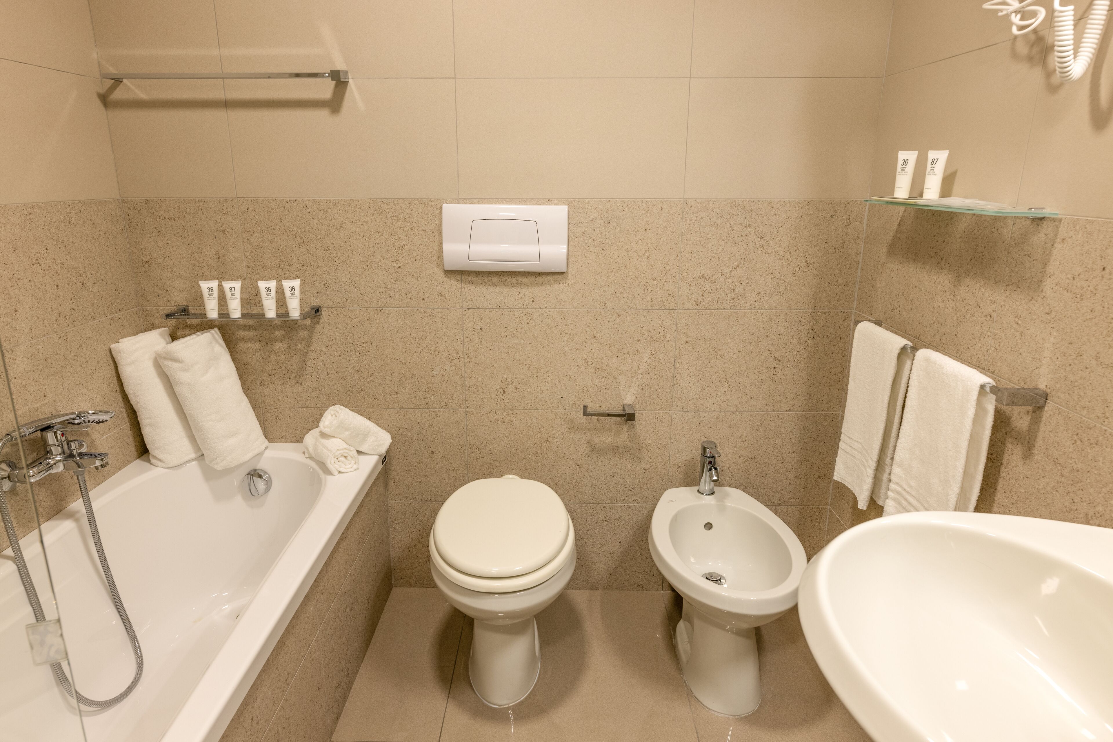 A bathroom with a bathtub, toilet, bidet, and sink.