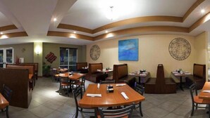 A restaurant with booths and tables, a blue painting on the wall, and decorative wall art. - Hyatt House Bentonville/Rogers (Rogers)