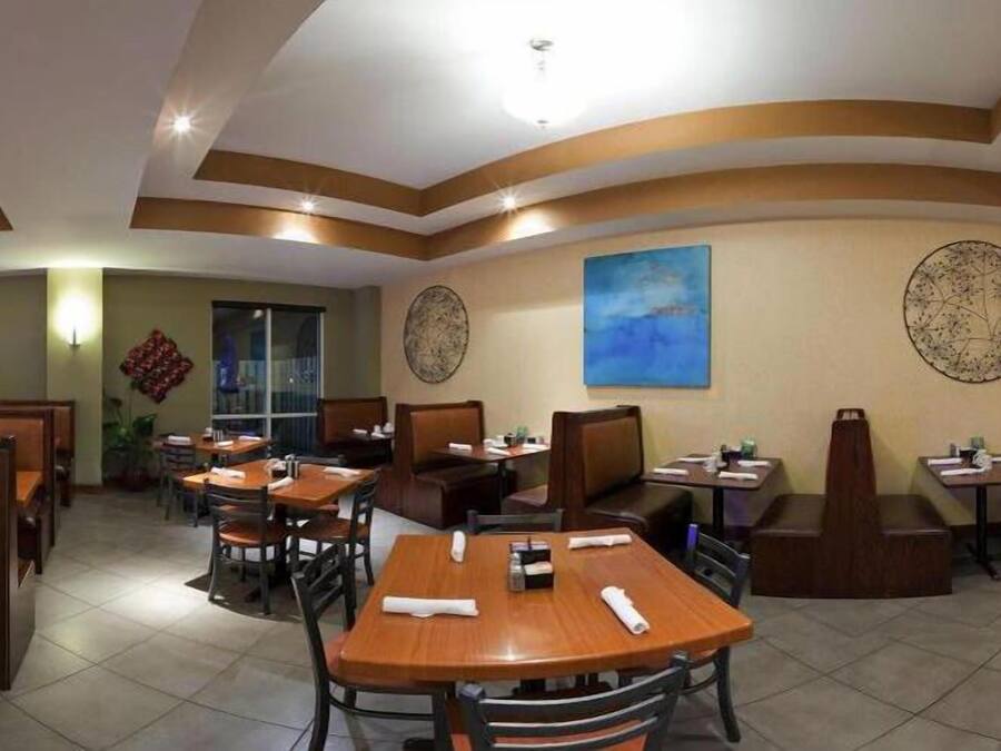 A restaurant with booths and tables, a blue painting on the wall, and decorative wall art.