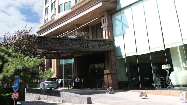 A multi-story hotel with a large glass facade and a classical architectural design. - Beijing Pudi Hotel (Beijing)