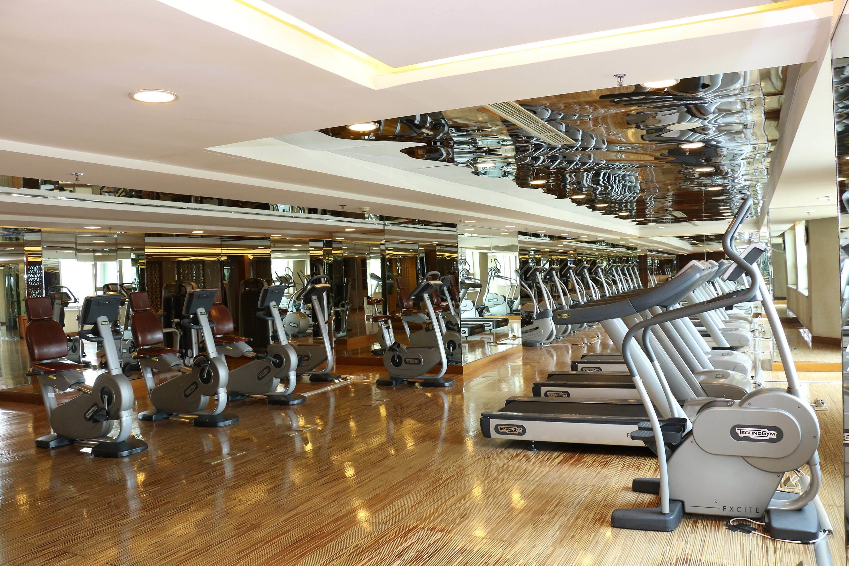 A gym with various exercise equipment, including treadmills and stationary bikes.