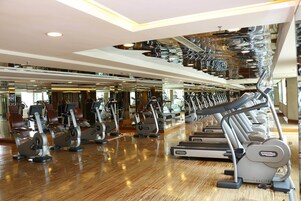 A gym with various exercise equipment, including treadmills and stationary bikes.