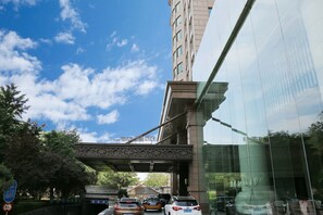 Un bâtiment moderne doté d’une façade en verre et d’un pont décoratif qui le surplombe.