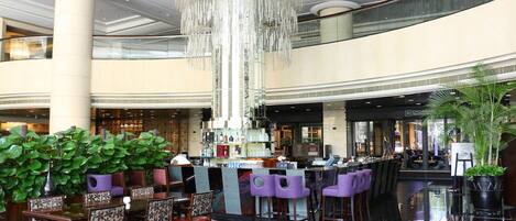 Eine geräumige Lobby mit Bar, Sitzgelegenheiten und einem großen Kronleuchter.