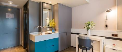 A modern kitchen with a built-in oven, a sink, and a dining area with a chair.