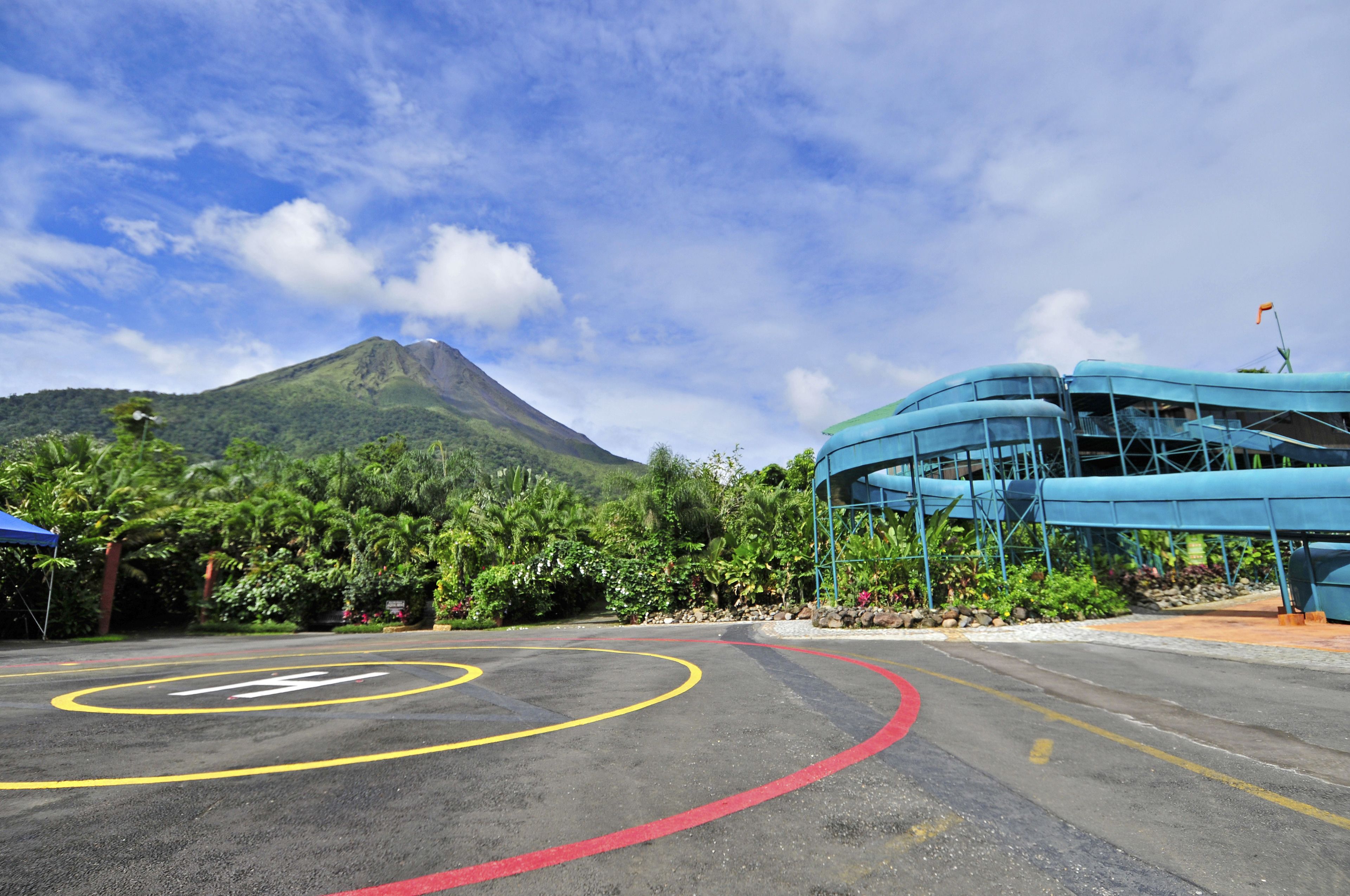 A parking area with marked lanes and a building with a blue roof.