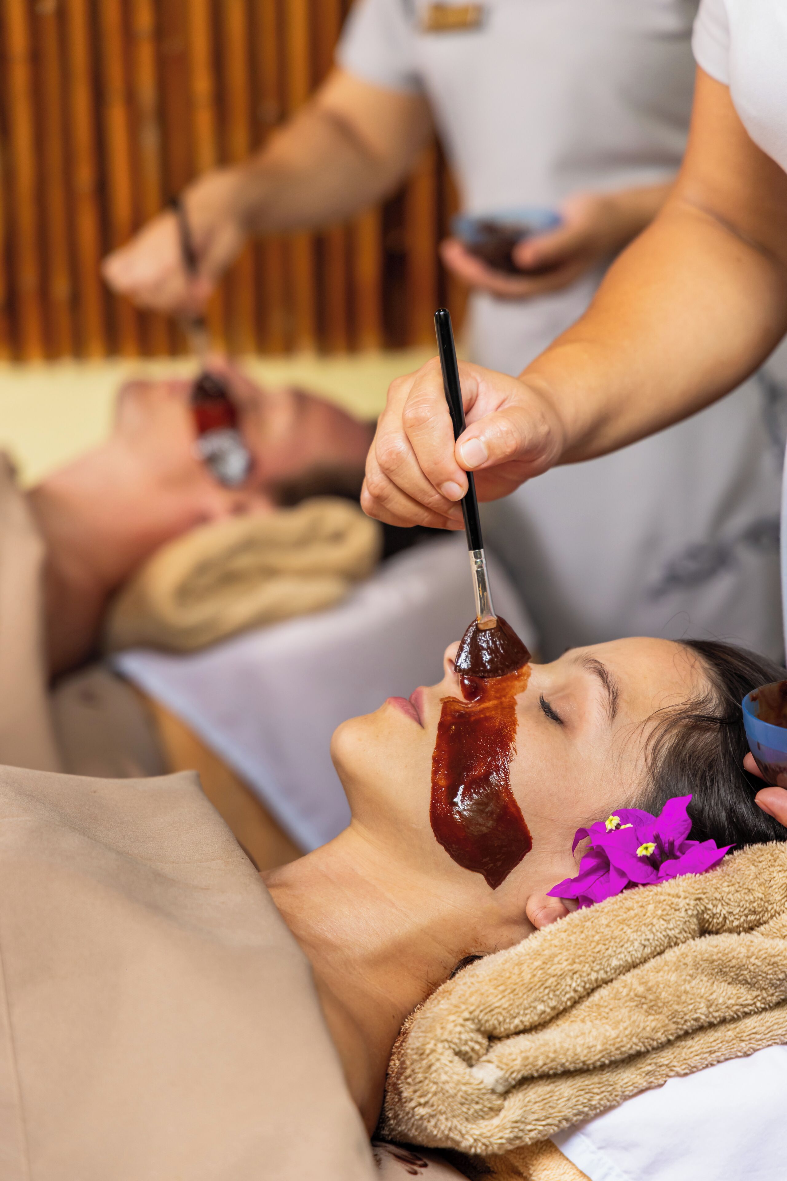 Una persona recibiendo un tratamiento facial con un líquido aplicándose.