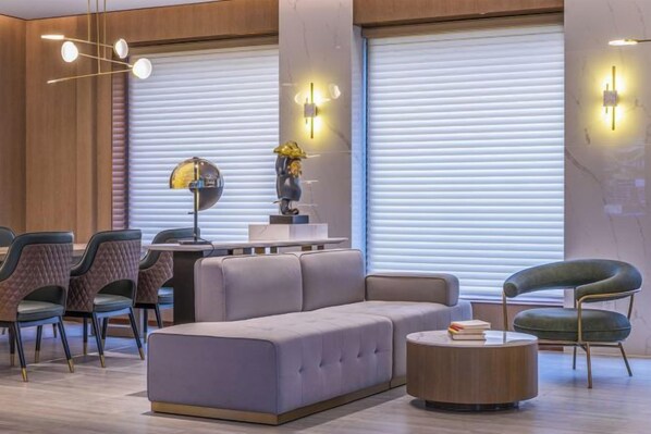 A modern interior with a sofa, dining table, chairs, and a round coffee table. - Zety Hotel (Beijing Wukesong Haidian Wuluju Subway Station) (Beijing)