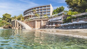 Un hotel con piscina, zona de estar al aire libre y vistas al agua.