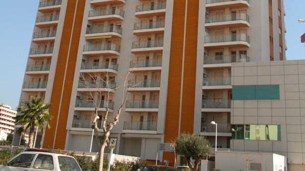 A high-rise building with multiple balconies and a modern architectural design. - Apartamentos Ambar Beach (Calpe)