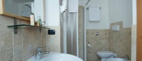 Un baño con lavamanos, espejo y dos inodoros.