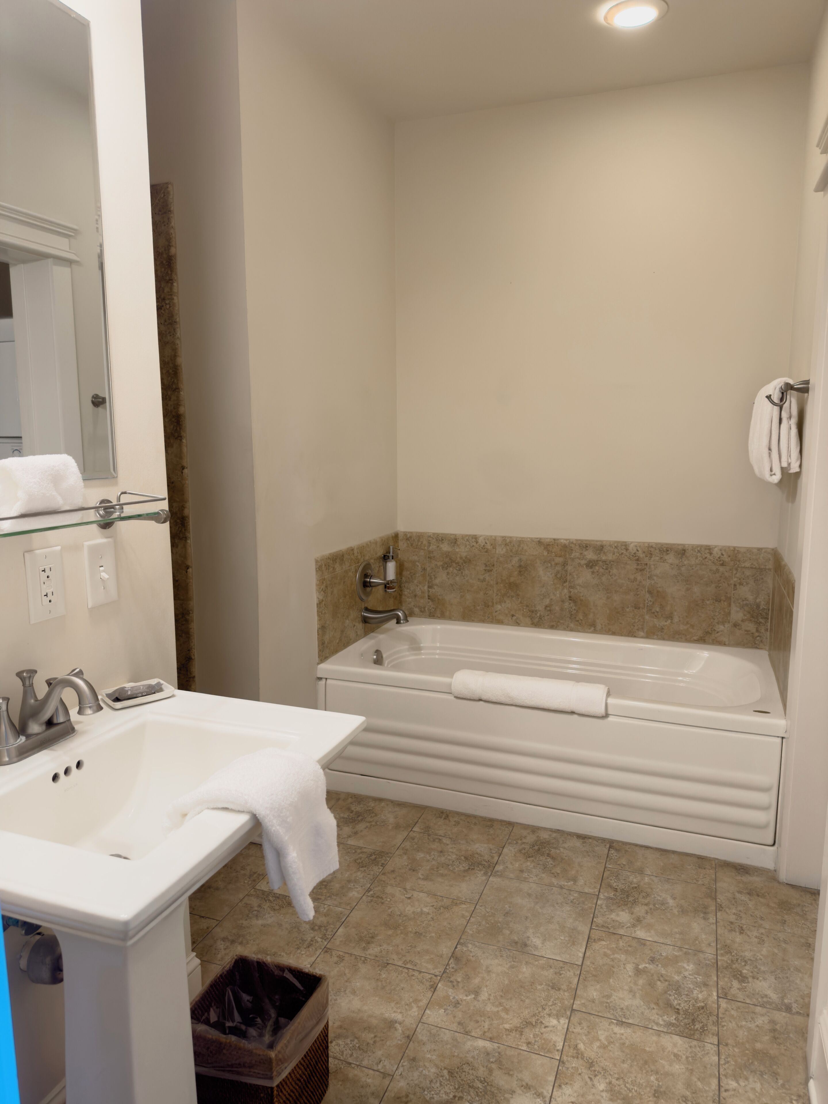 Un baño con bañera, lavamanos y espejo.