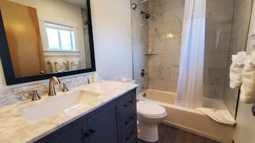 Een bad/douchecombinatie, milieuvriendelijke toiletartikelen, handdoeken