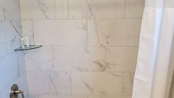 Tina con regadera, amenidades de baño ecológicas, toallas