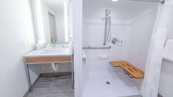 A modern bathroom with a shower, sink, and mirror.