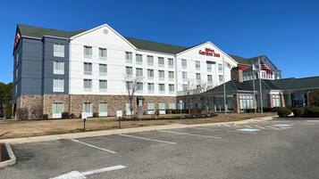 Un hotel moderno con facciata bianca, numerose finestre e una bandiera americana ben visibile.