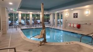Een binnenzwembad met helder water, een badmeesterstoel en een bord met 'NO DIVING' op de muur.