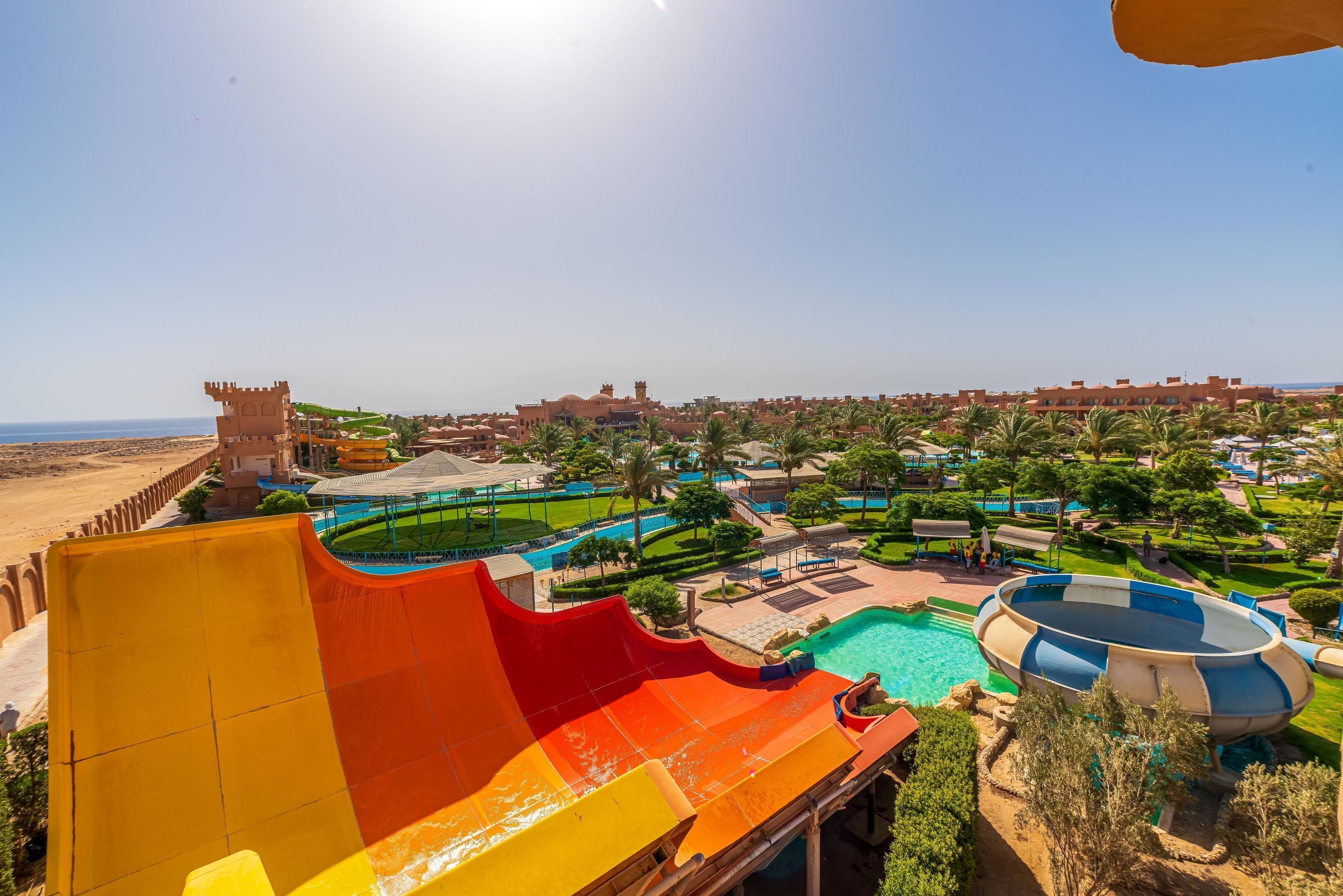 A water park with a large slide, a pool, and a castle-like structure.