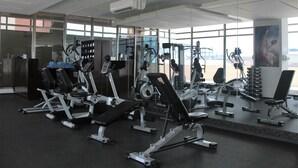 A gym with various exercise equipment, large windows, and a view of the outside. - Radisson Colon 2000 Hotel & Casino at Cruise Port & Duty Free Mall (Colon)