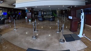 A lobby with a curved ceiling, a reception desk, seating area, and a TV screen. - Radisson Colon 2000 Hotel & Casino at Cruise Port & Duty Free Mall (Colon)
