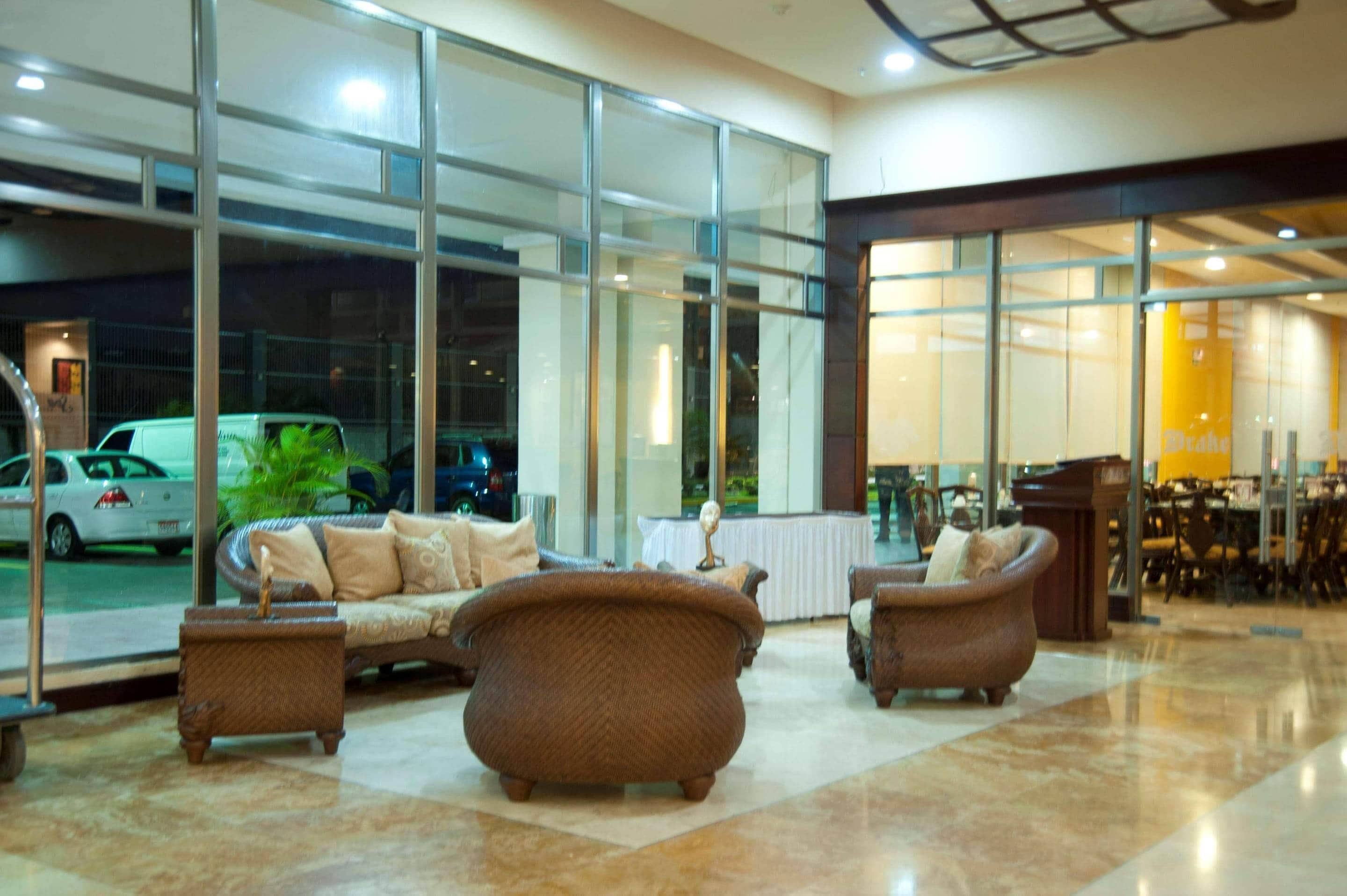 A lobby with a seating area, large windows, and a view of the street outside.
