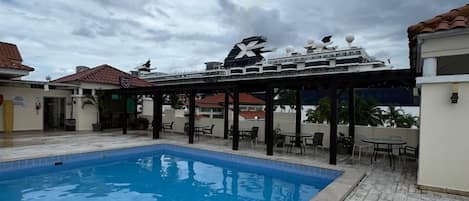 Una piscina al aire libre, sillones reclinables de piscina
