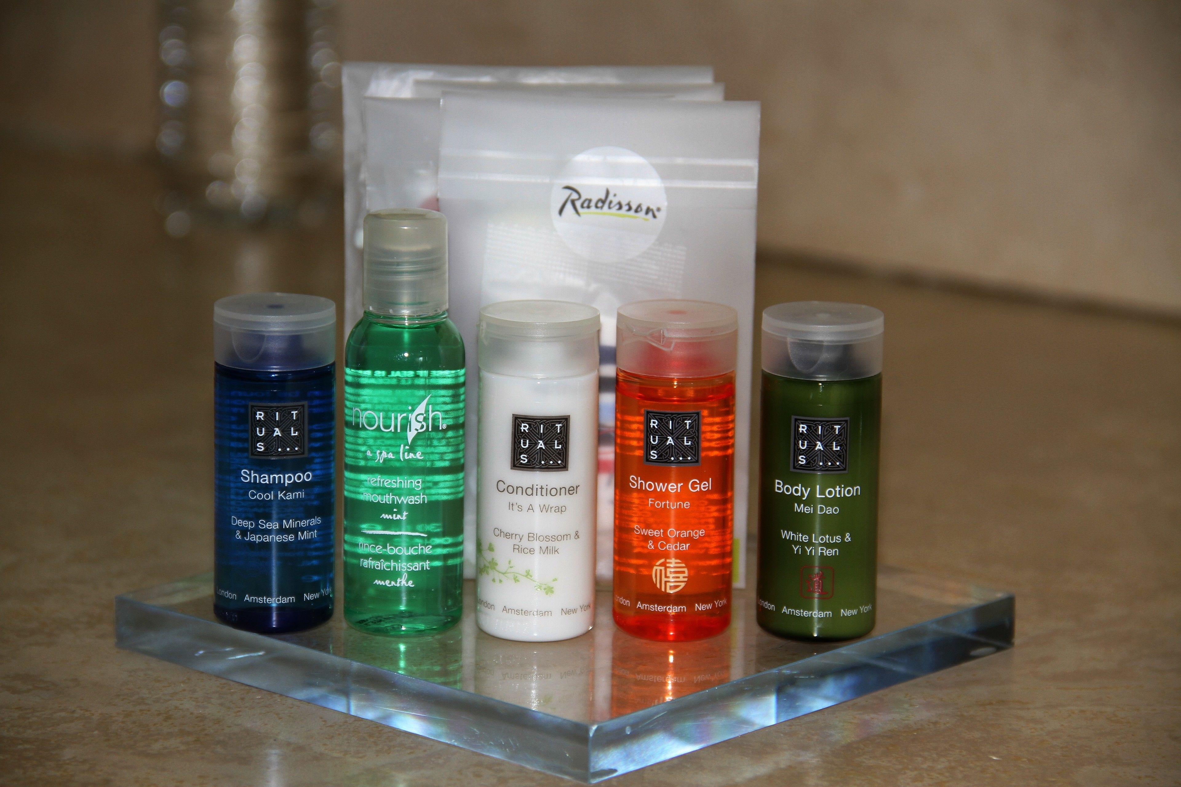 Une sélection de produits de soins personnels exposée sur un présentoir transparent en acrylique.