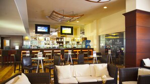 A bar area with a television, bar counter, and seating arrangement. - Radisson Colon 2000 Hotel & Casino at Cruise Port & Duty Free Mall (Colon)