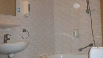 A bathroom with a sink, toilet, and shower.