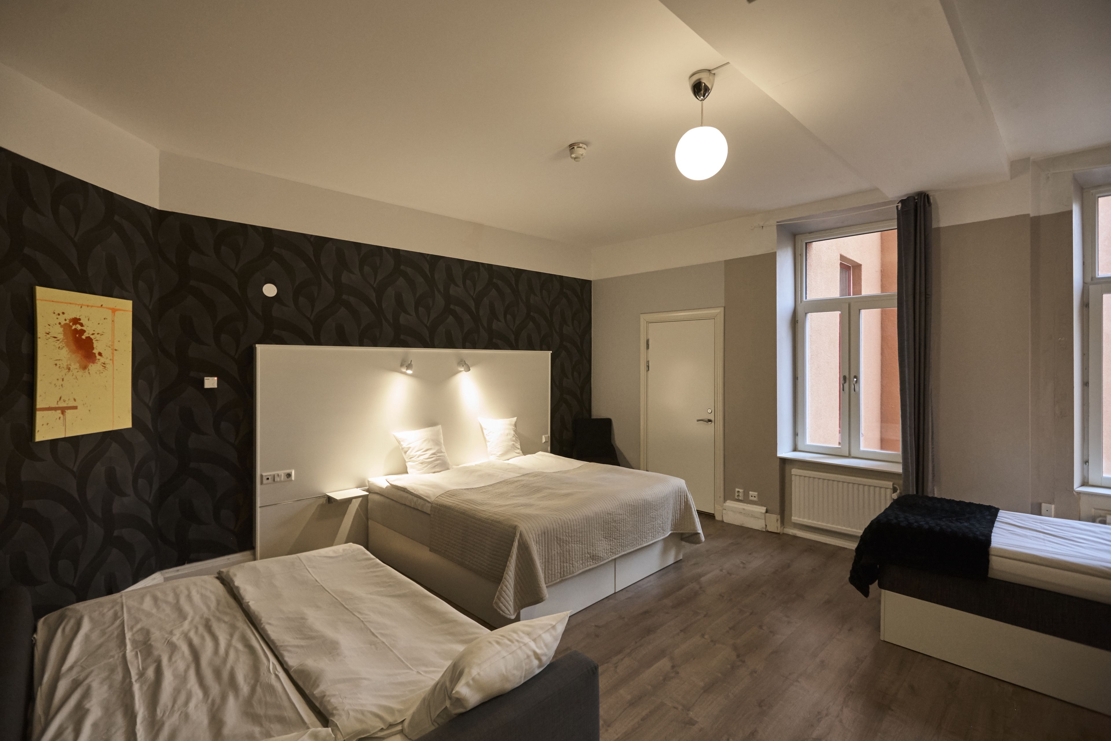 Een hotelkamer met twee bedden, een groot raam en een modern design.