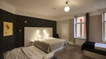 Een hotelkamer met twee bedden, een groot raam en een modern design.