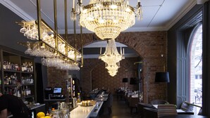 Zona de bar con candelabro, mostrador de madera y asientos.