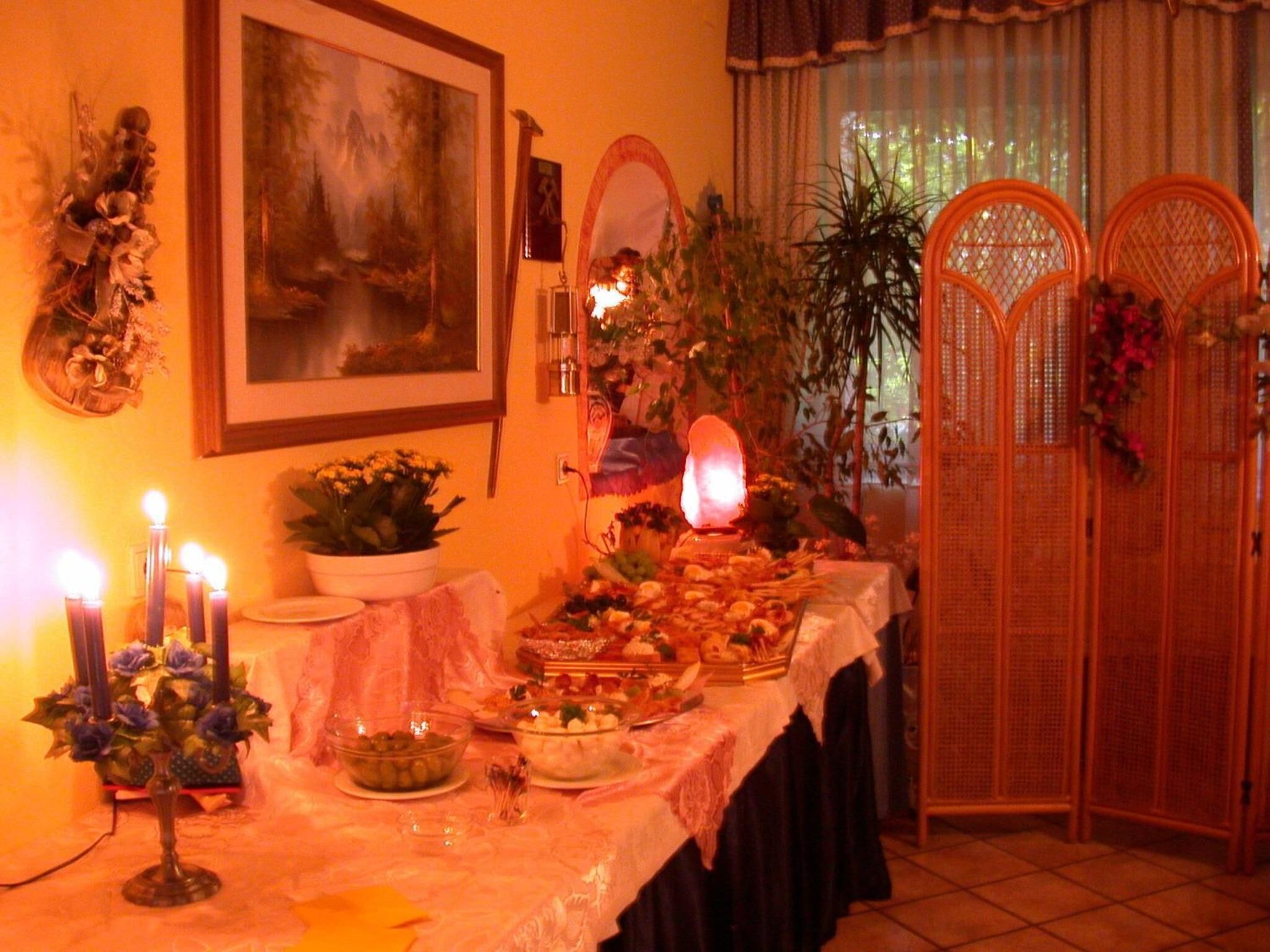 A dining table with various dishes and a lit candle centerpiece.