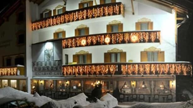 A multi-story hotel with balconies, a fireplace, and a snow-covered ground. - Hotel Tschurtschenthaler (Dobbiaco)