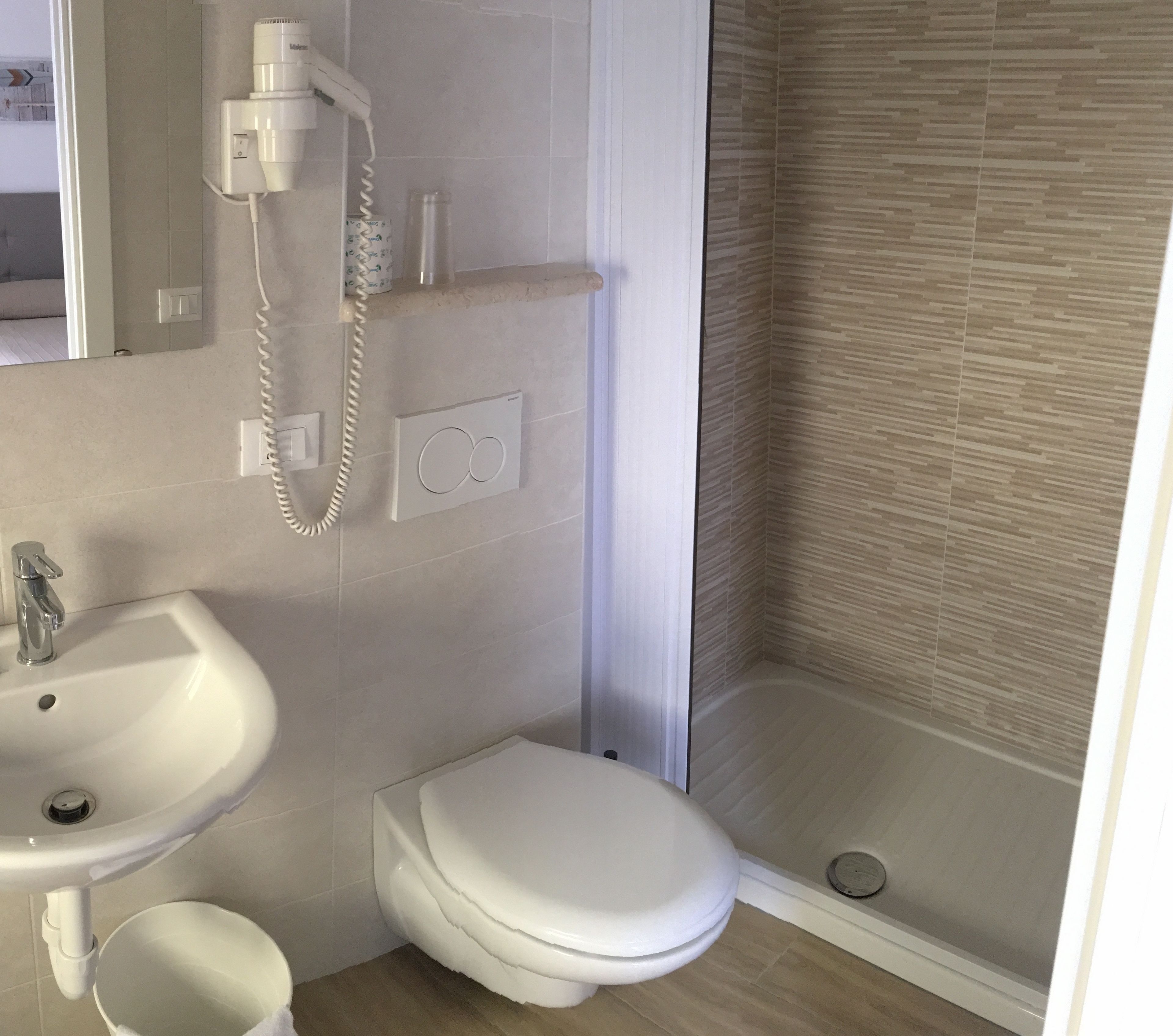 A bathroom with a sink, toilet, and shower.