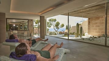 Relax in a tranquil space with two reclining chairs, towels, and a serene garden view.