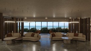 Un salon spacieux offrant une vue sur l’océan, aménagé avec des canapés et des tables basses pour favoriser la détente.
