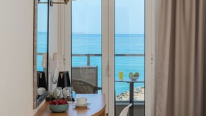 A hotel room with a balcony, a coffee maker, a bowl of strawberries, a cup, and a lamp. - Themis Beach Hotel (Hersonissos)