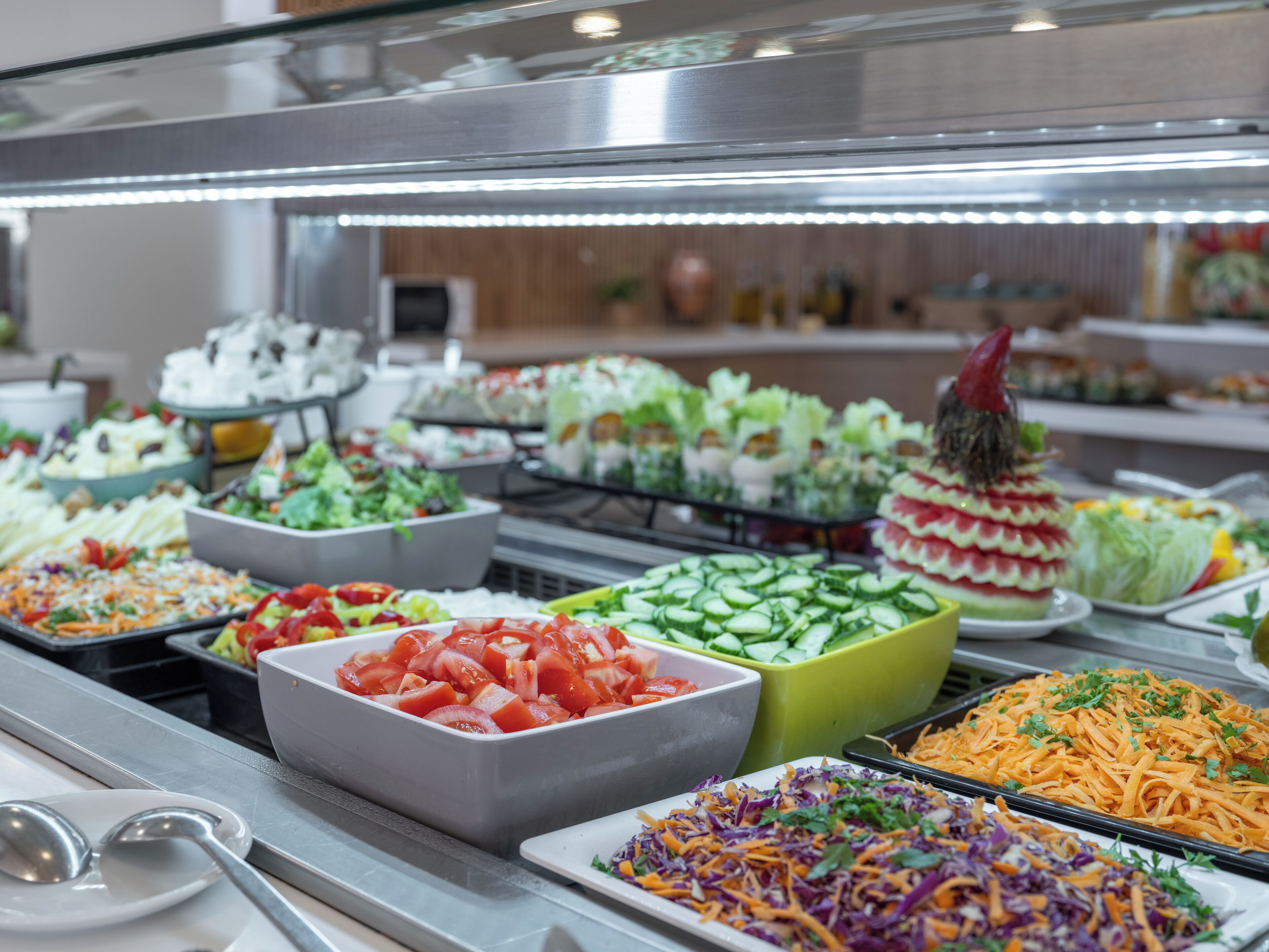 Ein Buffet mit verschiedenen Gerichten, darunter Salate, Gemüse und Beilagen.